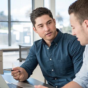 two men working on laptop